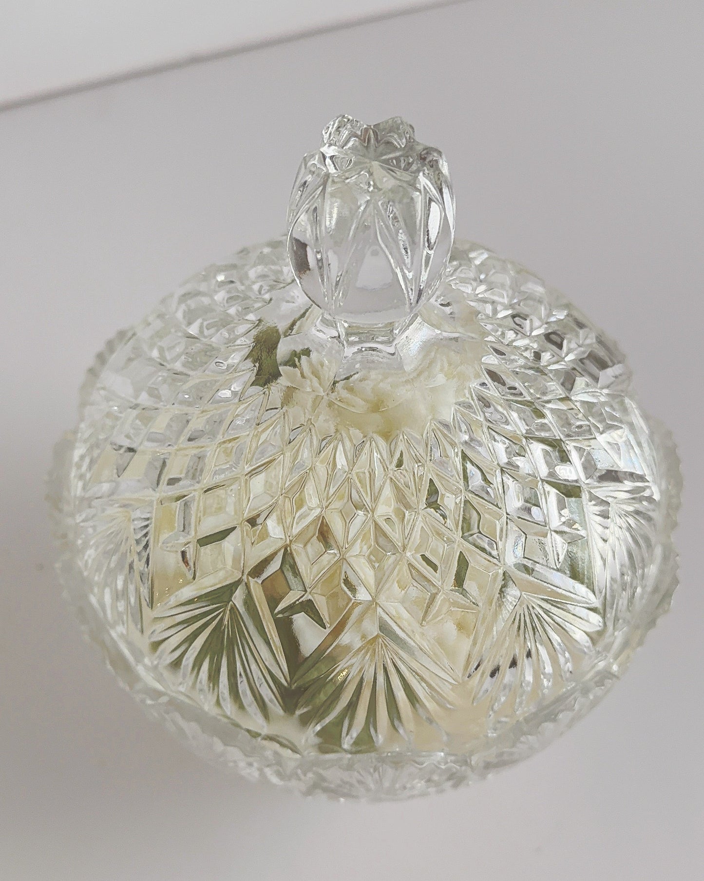 Decorative glass candy dish with lid on a white background