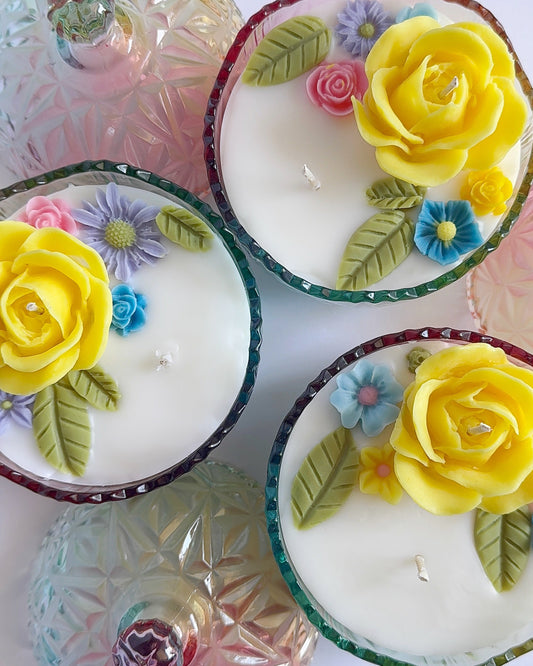 Decorative candles with floral designs on a white background