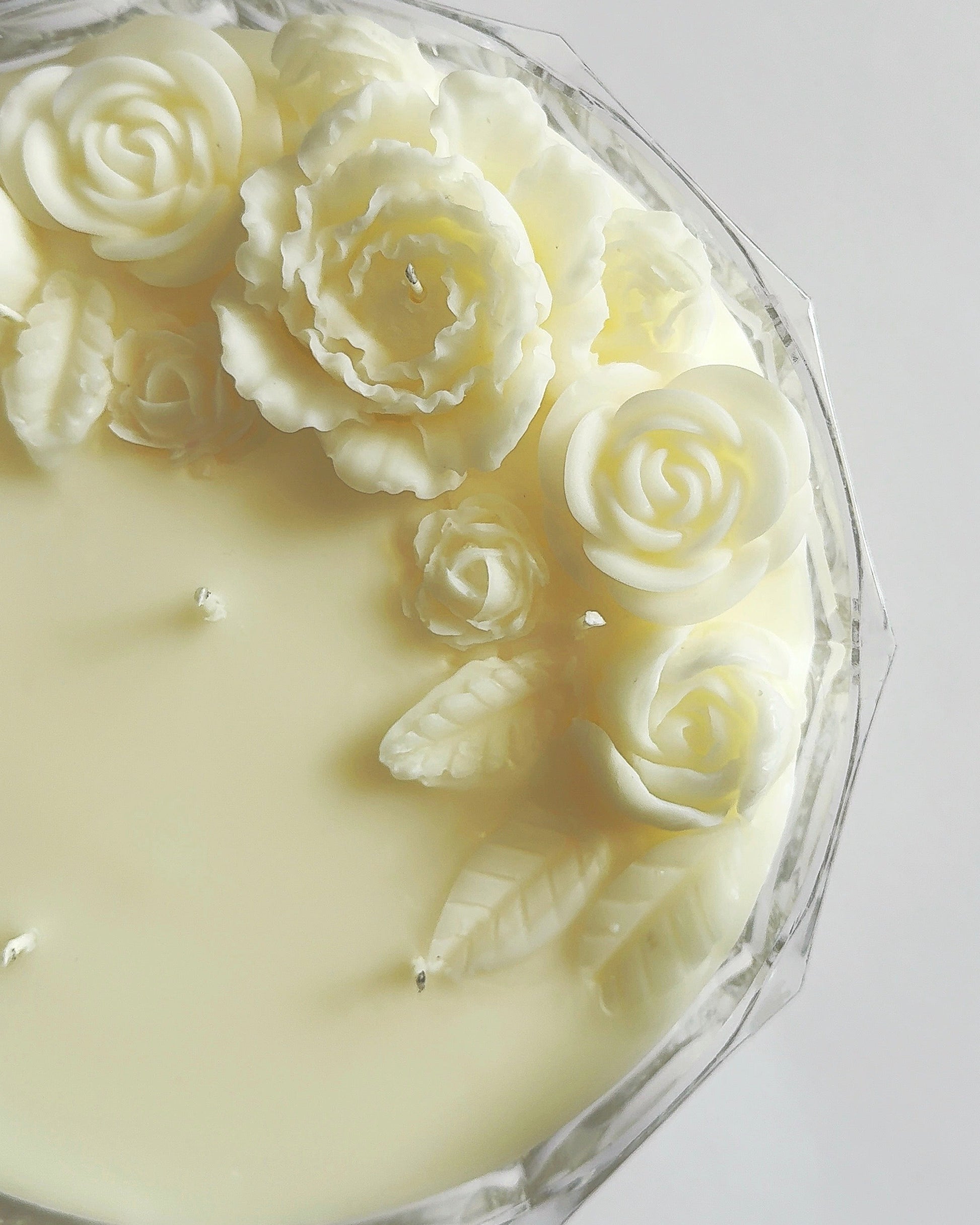 Candle with rose-shaped wick on a white background