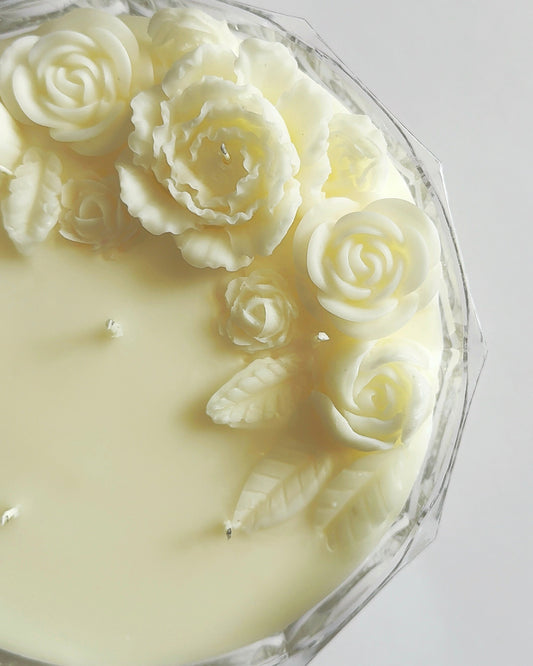 Candle with rose-shaped wick on a white background