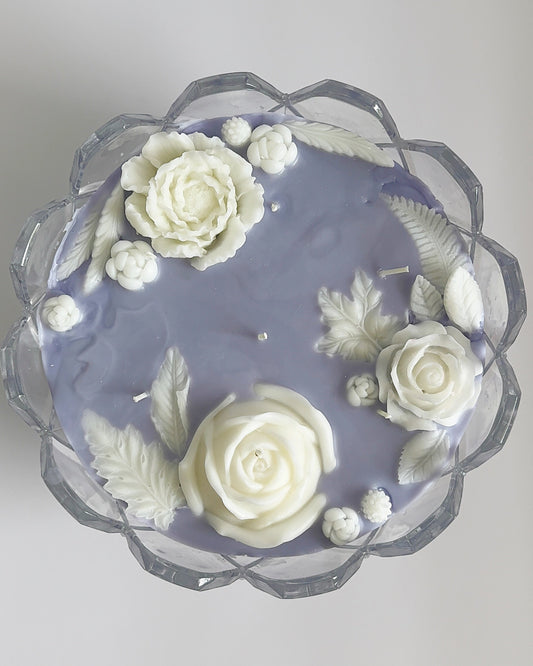 Decorative candle with white flowers on a light gray background