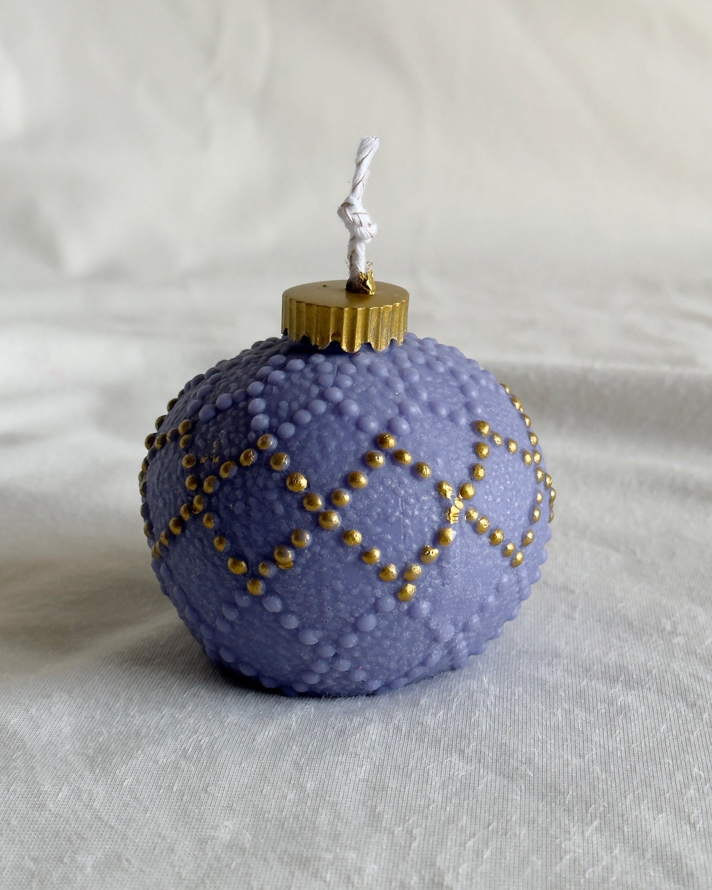 Decorative purple ornament candle with gold accents 