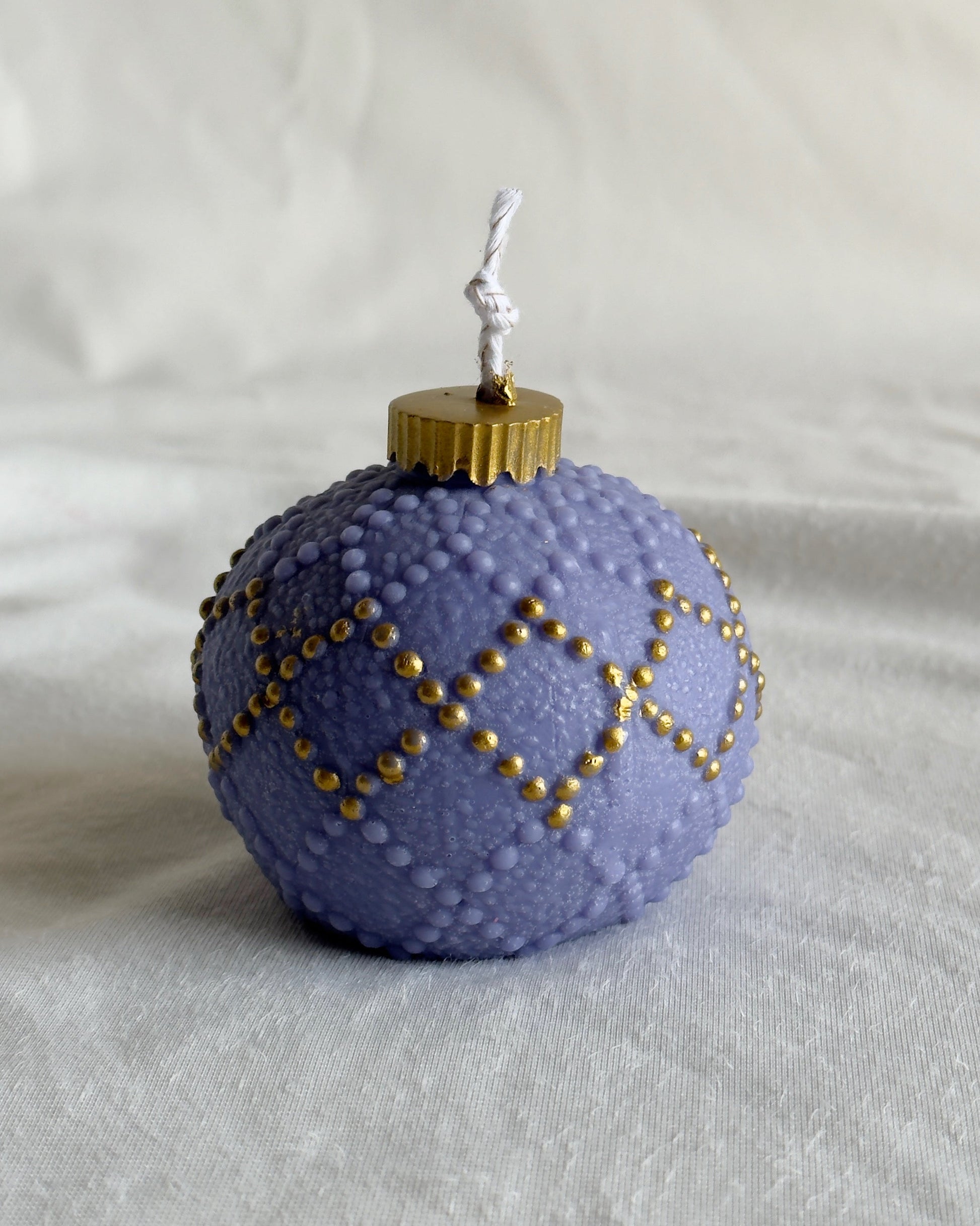 Decorative purple ornament candle with gold accents 
