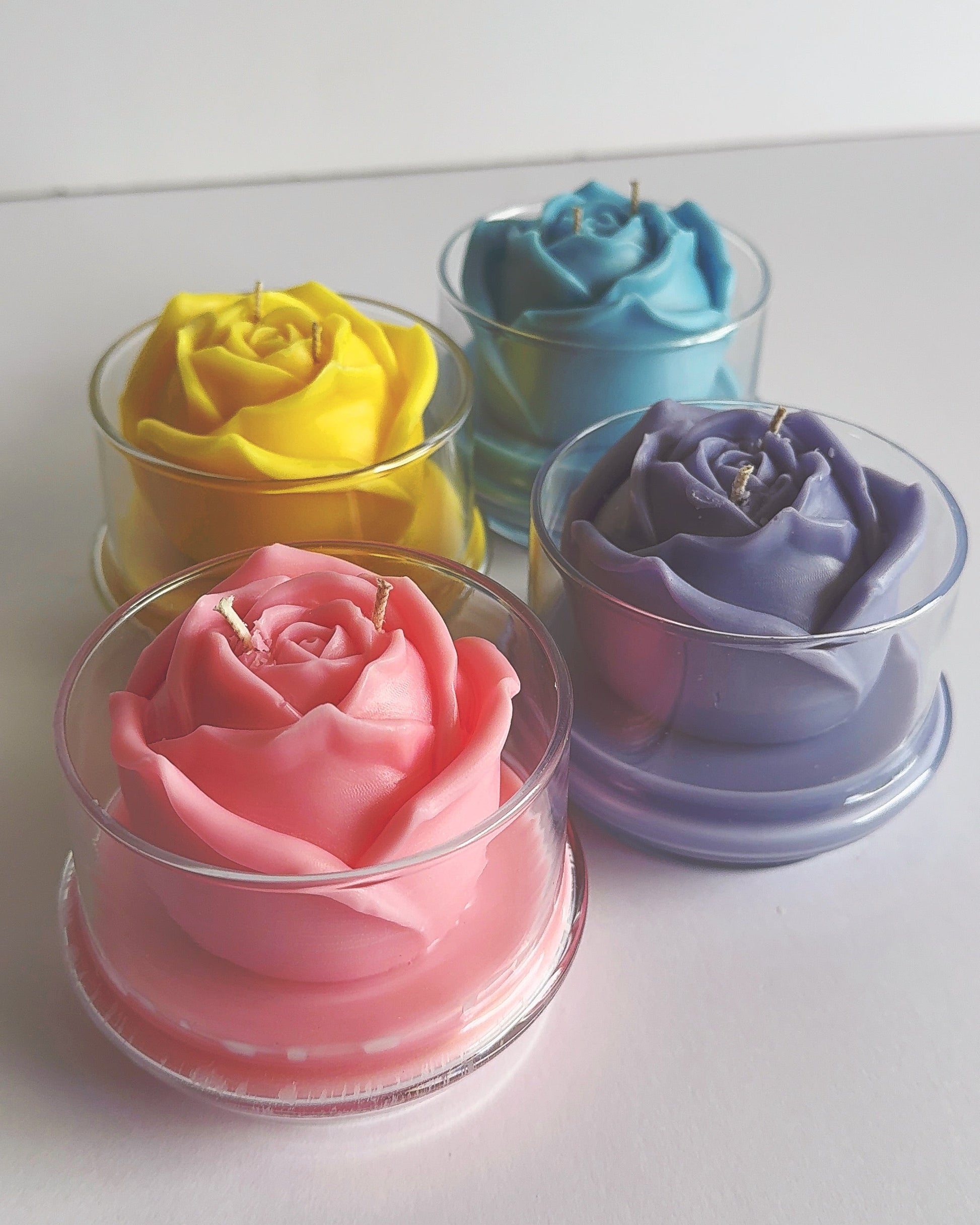 Four glass dish with cloche dome with colorful rose-shaped candles 