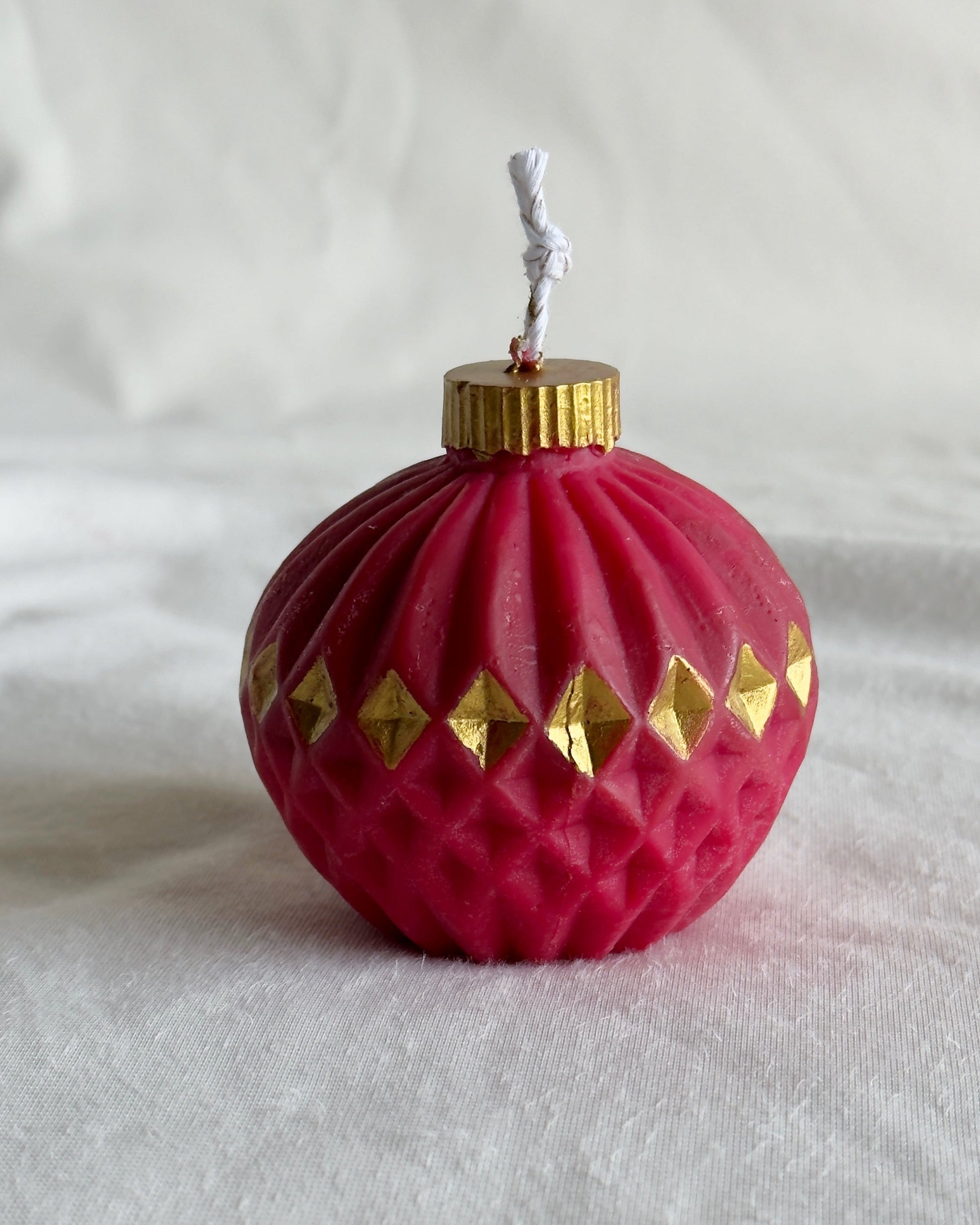 red Christmas ornament candle with gold accents 