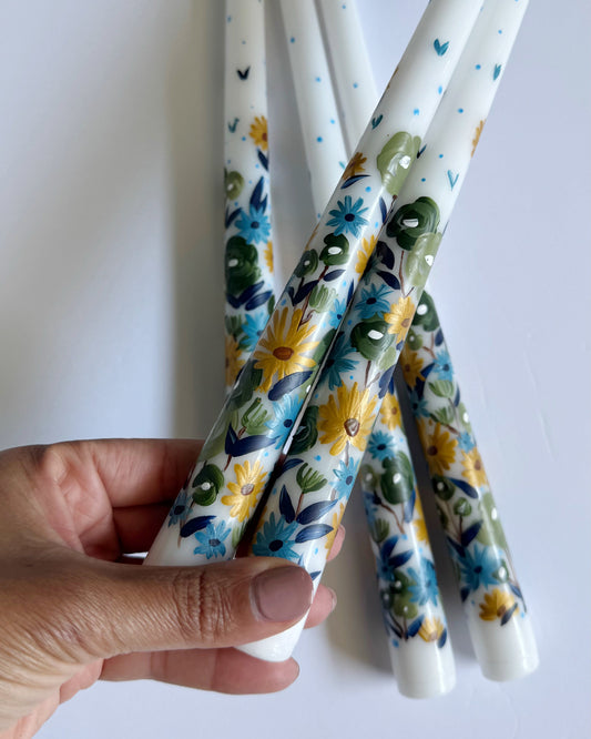 Three hand-painted taper white and blue candles with floral designs 