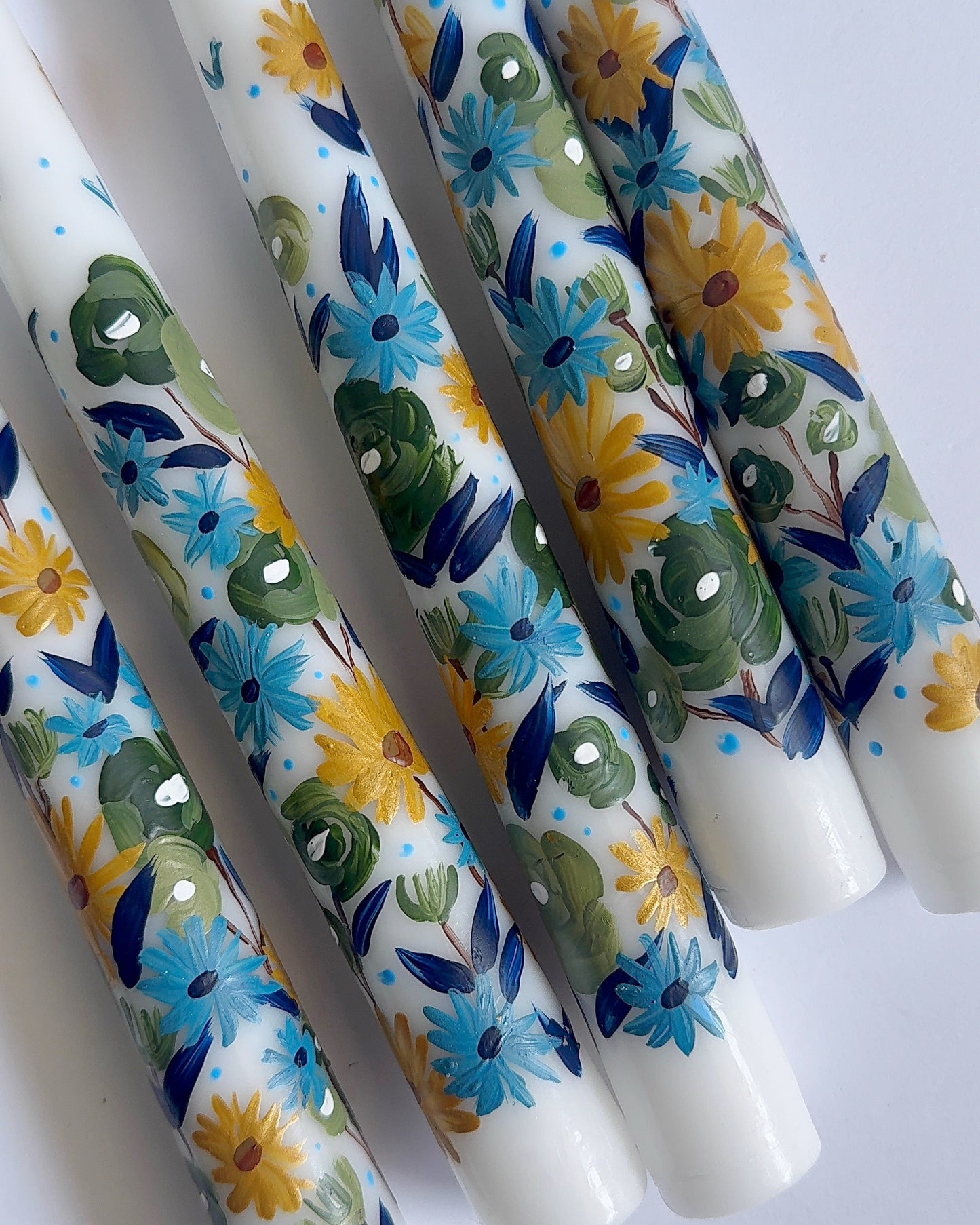 Three hand-painted taper white candles with floral designs 