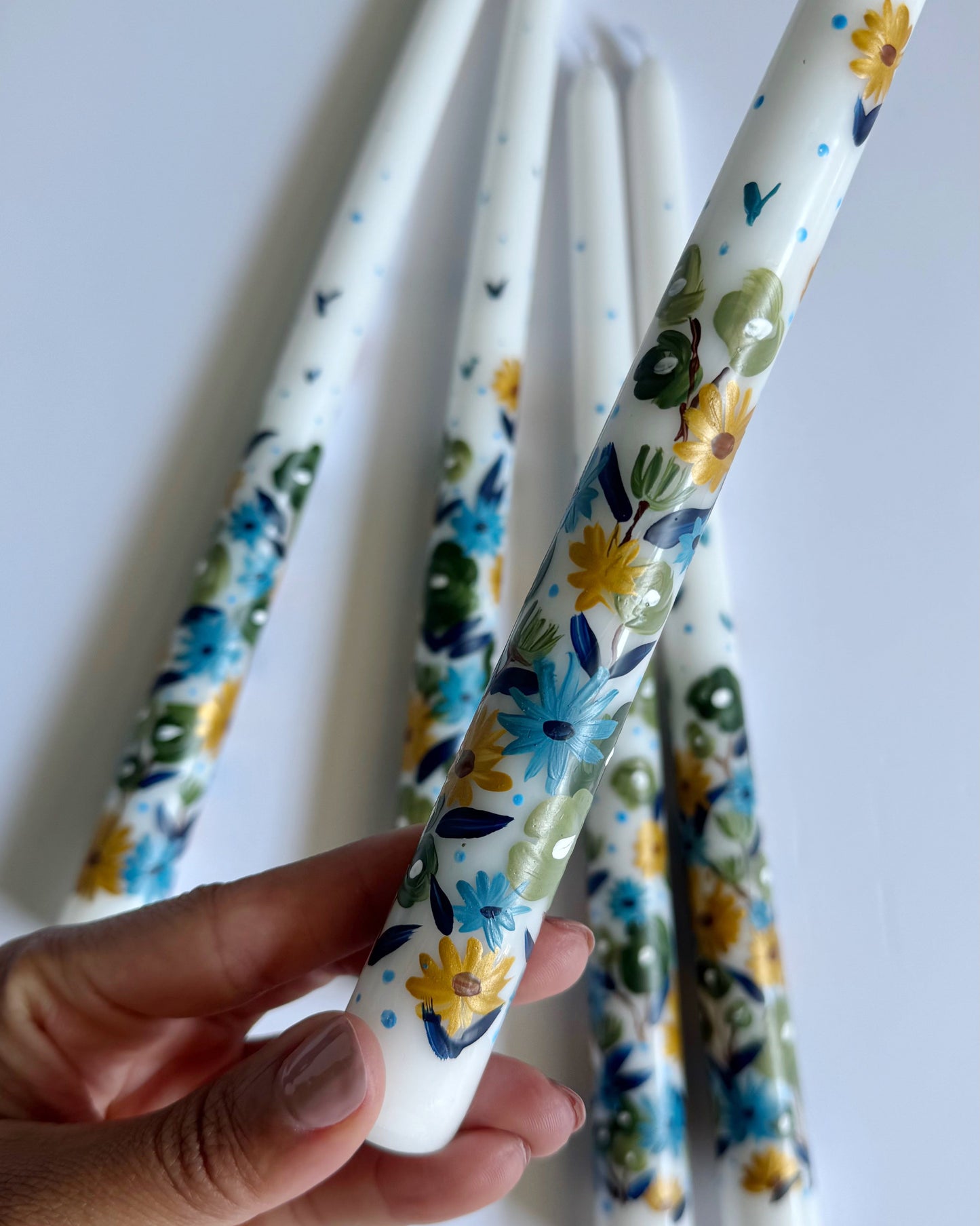 Three hand-painted taper white candles with floral designs 