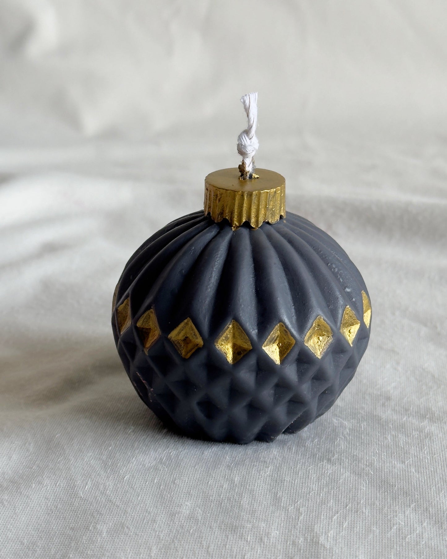 Decorative black ornament candle with gold accents
