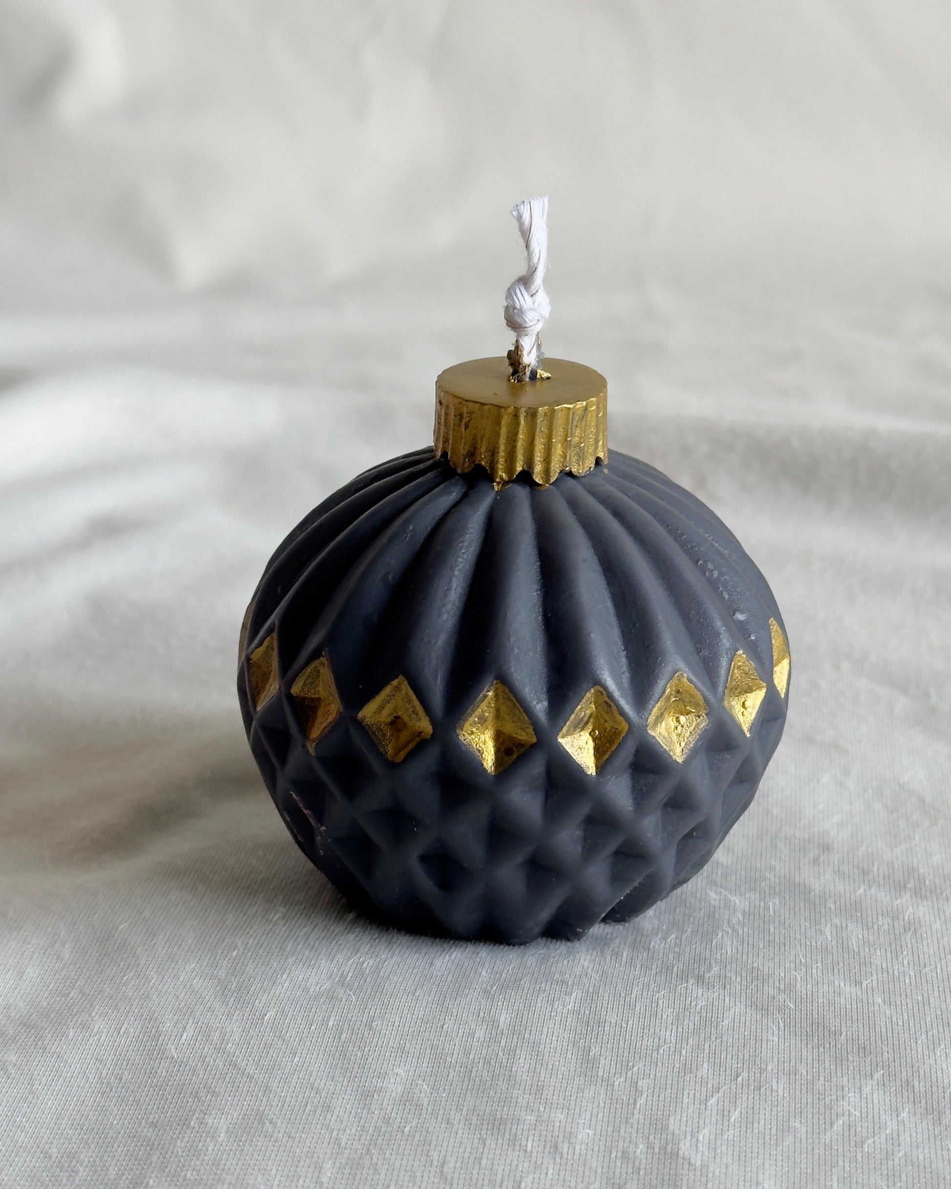 Decorative black ornament candle with gold accents