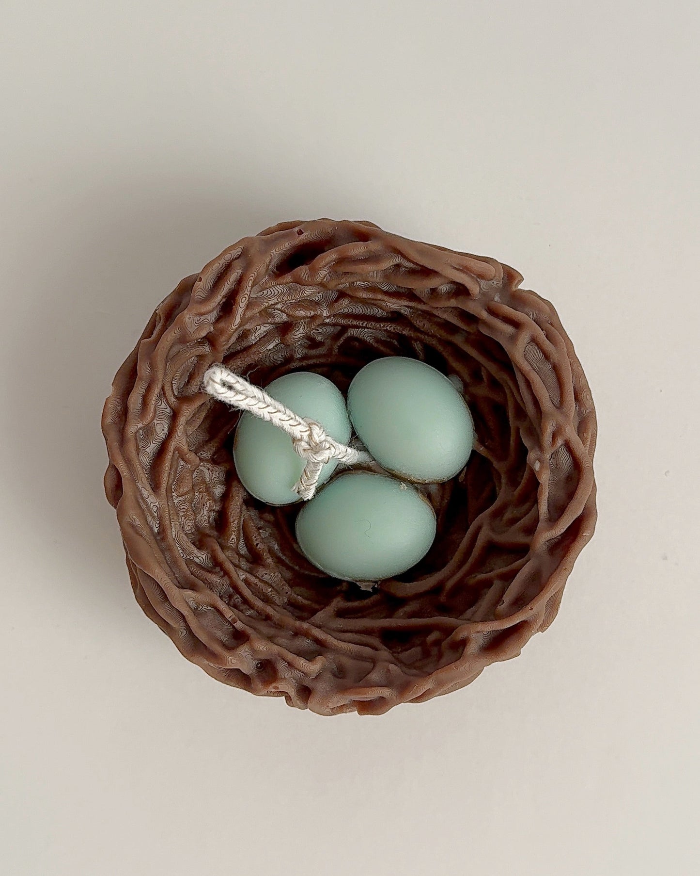 candle bird's nest with three light blue eggs