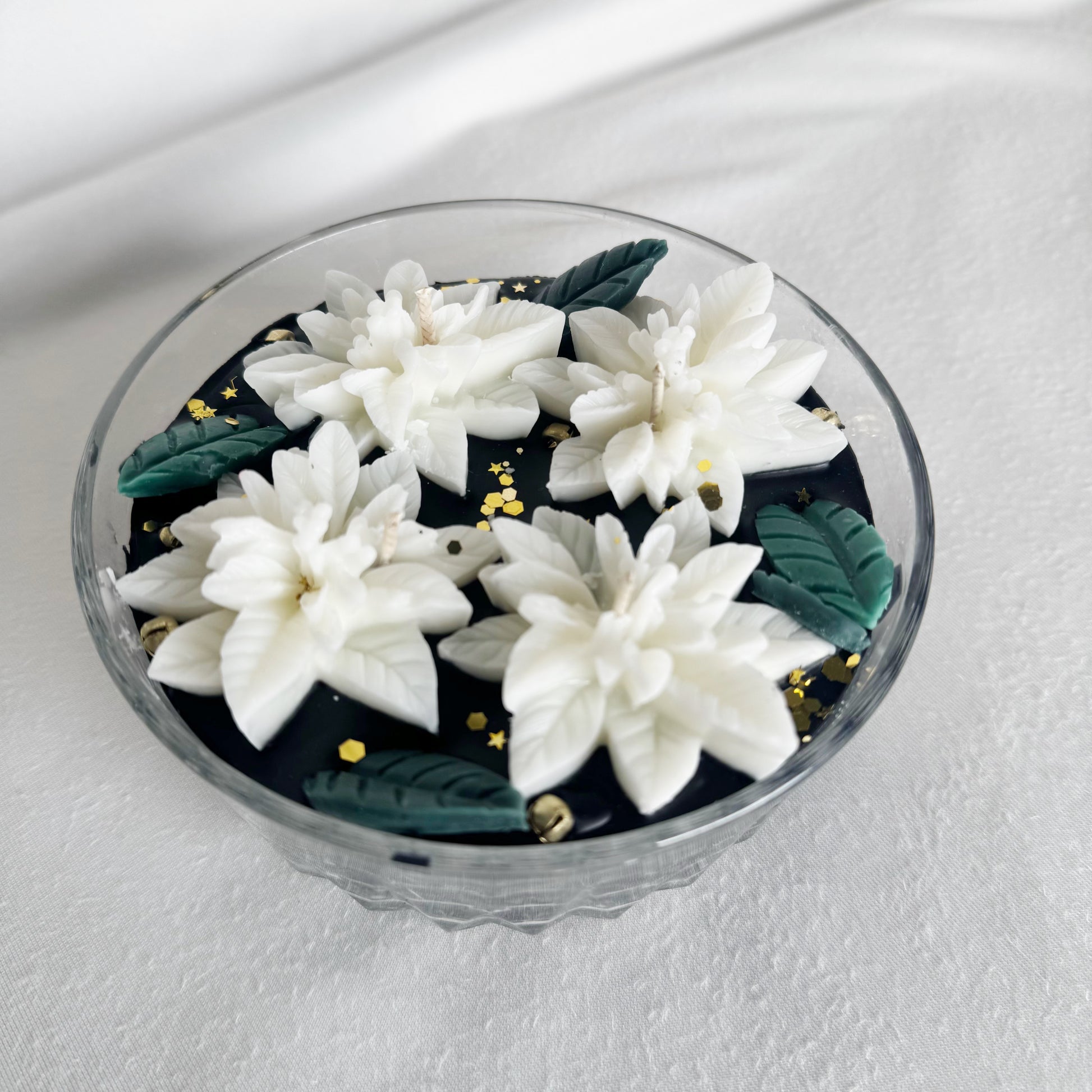 black candle decorative candle with white poinsettias holiday