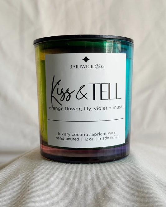 Candle with 'Kiss & Tell' label on a neutral background