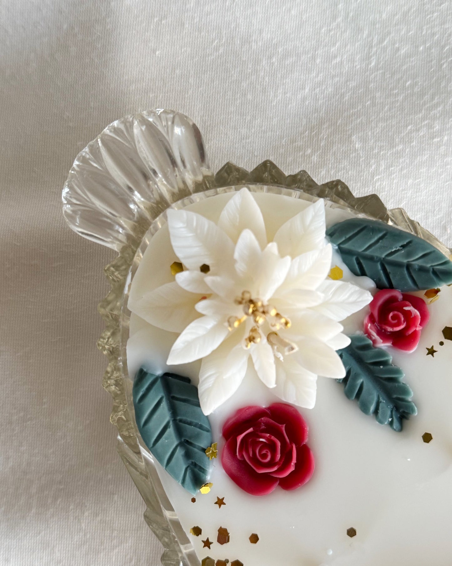 decorative_candle_poured_in_vintage_glass_dish_with_white_poinsettia