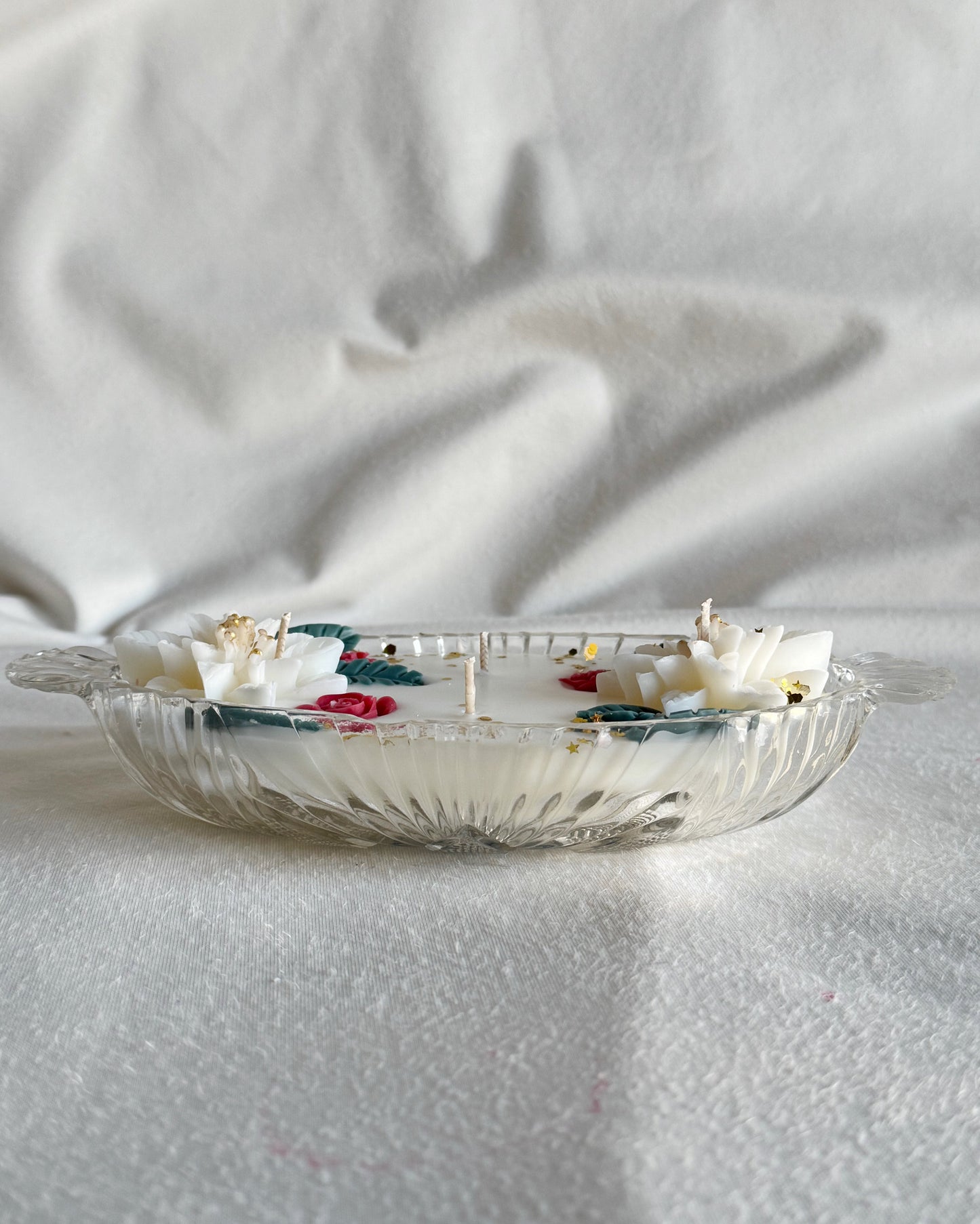 decorative_candle_poured_in_vintage_glass_dish_with_white_poinsettia