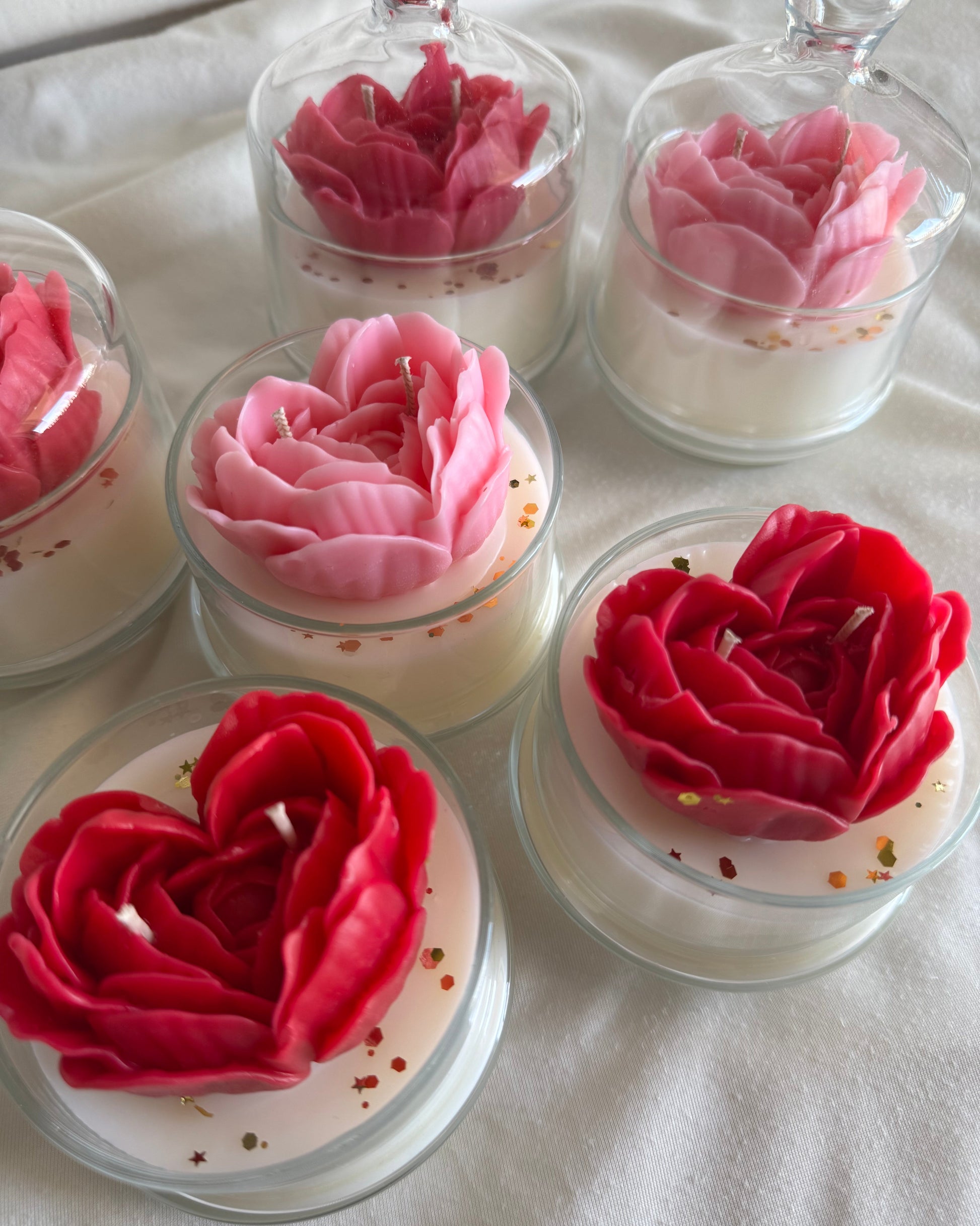 Decorative candles shaped like roses on a white surface