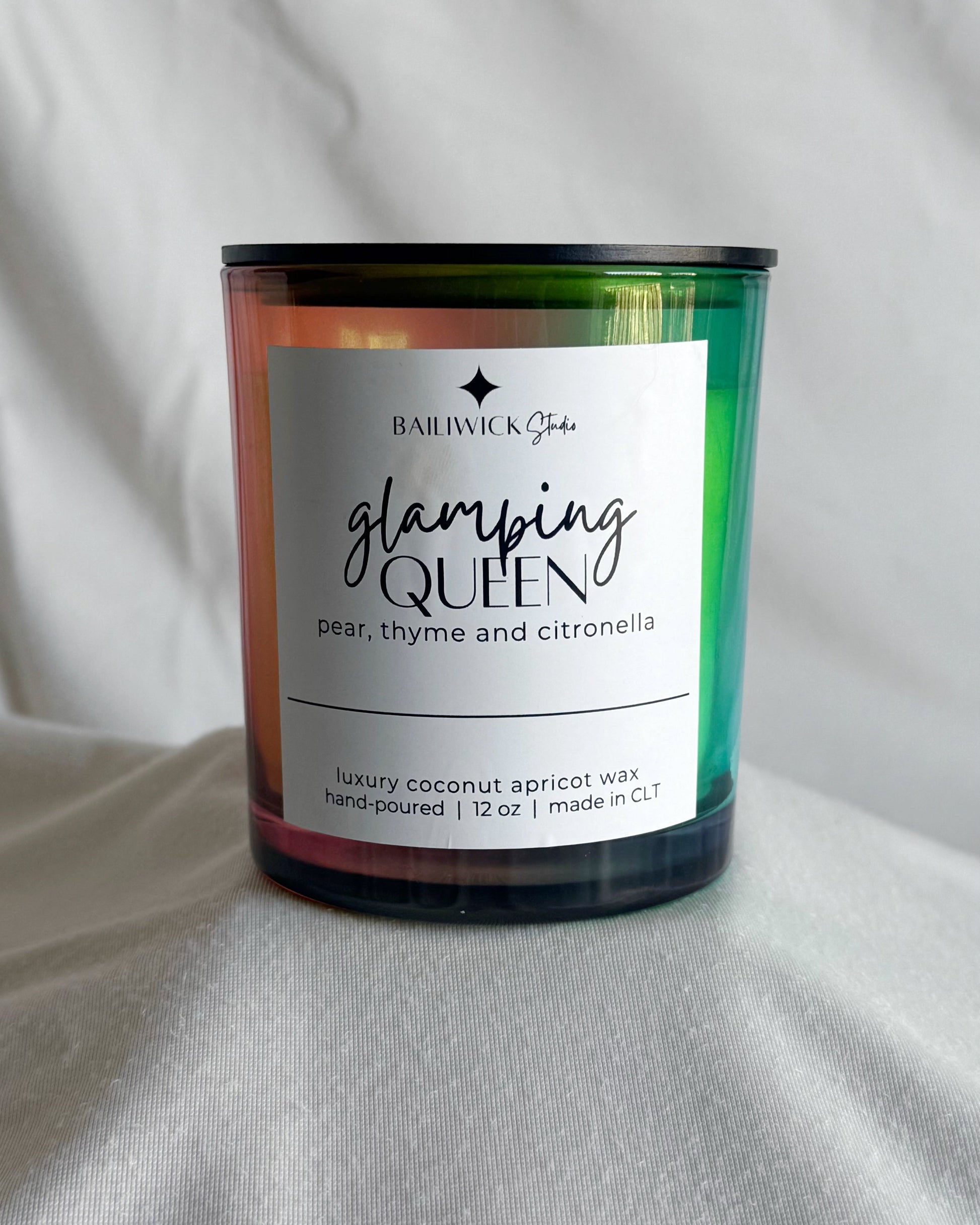 Candle labeled 'Glamming Queen' with a colorful label on a white background